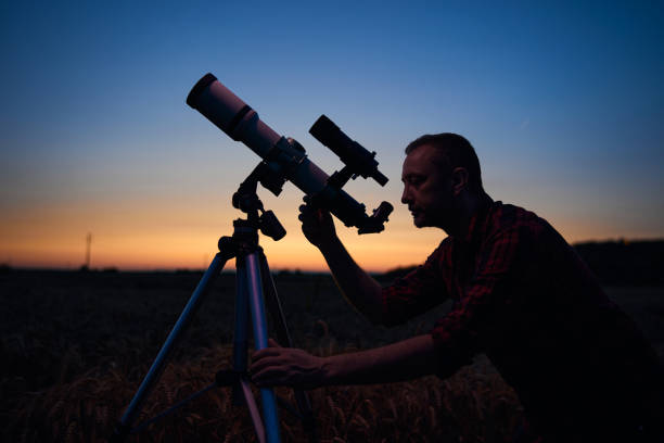 istock Astronomer looking at night sky with a telescope. 1864994505