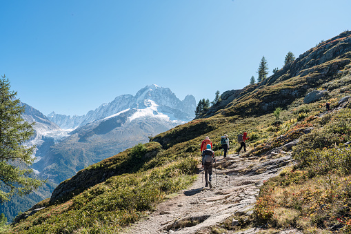 Scale view of women hiker climbing the mountain at sunset.