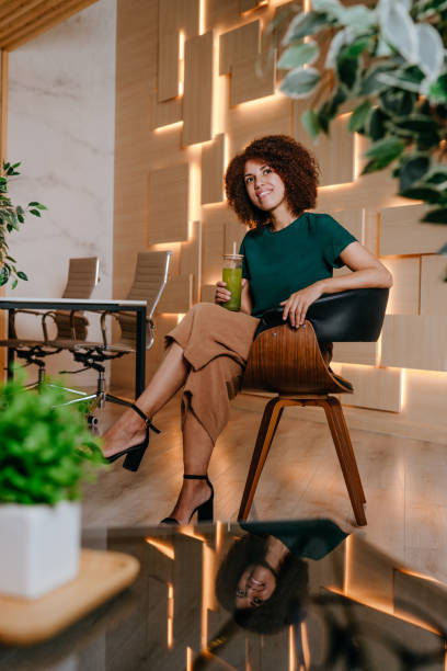 istock Woman using laptop drinking green smoothie with bamboo straw in the office 1865001537