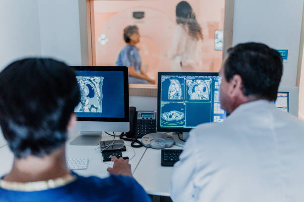 病院で断層撮影の医療用x線を解析する医師の背面 - human spine mri scan x ray doctor ストックフォトと画像