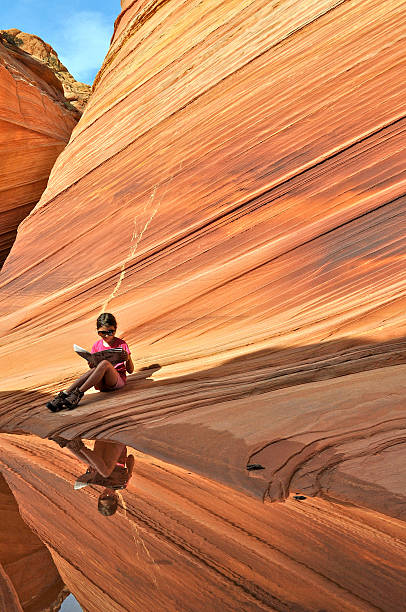 istock Girl reading newspaper in «the Wave» 186500670