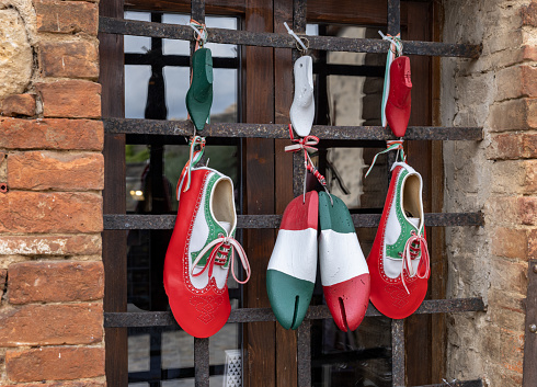 Monteriggioni, Italy - Sept 17, 2022: Decoration of a shoe store in a retro atmosphere and national colors of Italy in Monteriggioni. Tuscany.