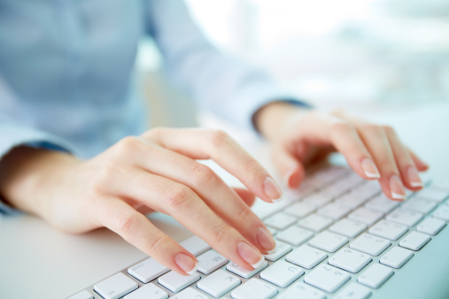 Female office worker typing on the keyboard