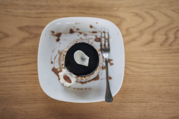 Tasty piece of sweet chocolate cake on a plate on table outdoors in cafe.
