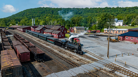 An Aerial View of a Narrow Gauge Steam passenger Train, Leaving the Yard for a Days Work, on a Sunny Summer Day