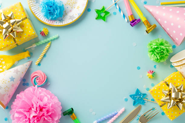 istock Lively festive display inspiration. Flat lay top view photograph featuring colorfully decorated table with celebration accessories, disposable plates, etc on pale blue background with space for text 1865103680