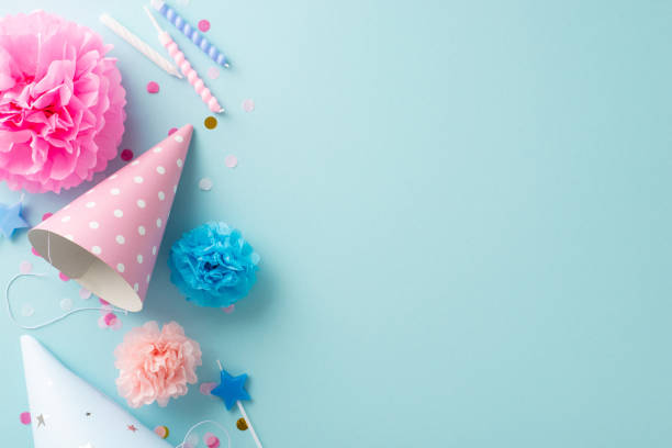 istock Uplifting festivity concept. Flat lay top view image featuring table set with celebratory embellishments, candies, celebration headgear, candles, confetti, against light blue backdrop for text or ads 1865103704