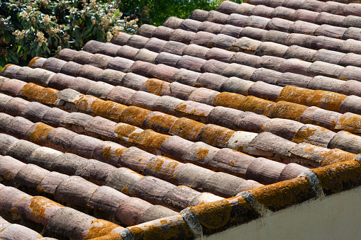 Detail of curved and textured, terracotta roof tiles used in home construction throughout Spain, Italy and Portugal and other southern European regions.