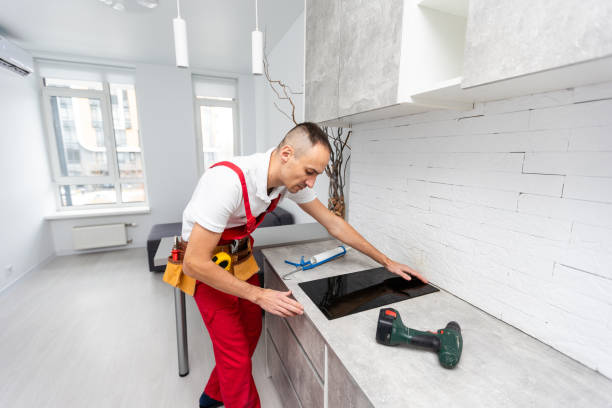 istock Young Repairman Installing Induction Cooker In Kitchen 1865112337
