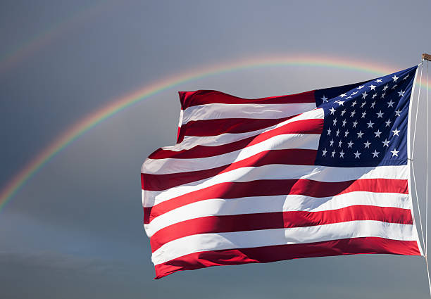 istock American flag against cloudy sky with a rainbow 186515300