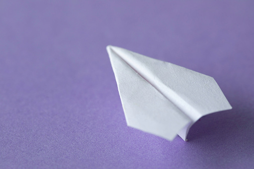 Paper airplane on purple background.