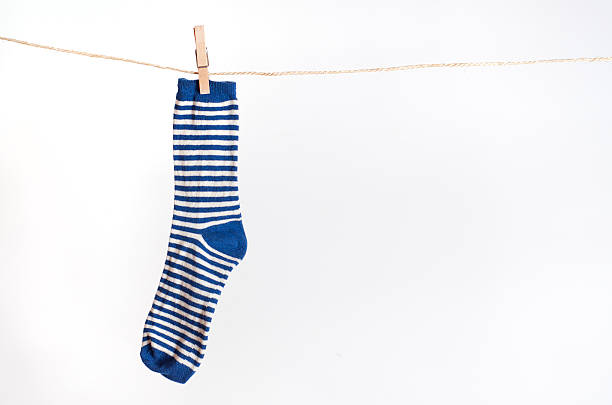 Blue and white striped sock hanging from a rope stock photo