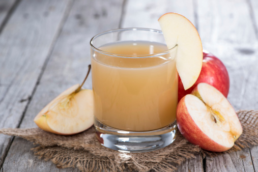Glass filled with fresh Apple Juice on wooden background