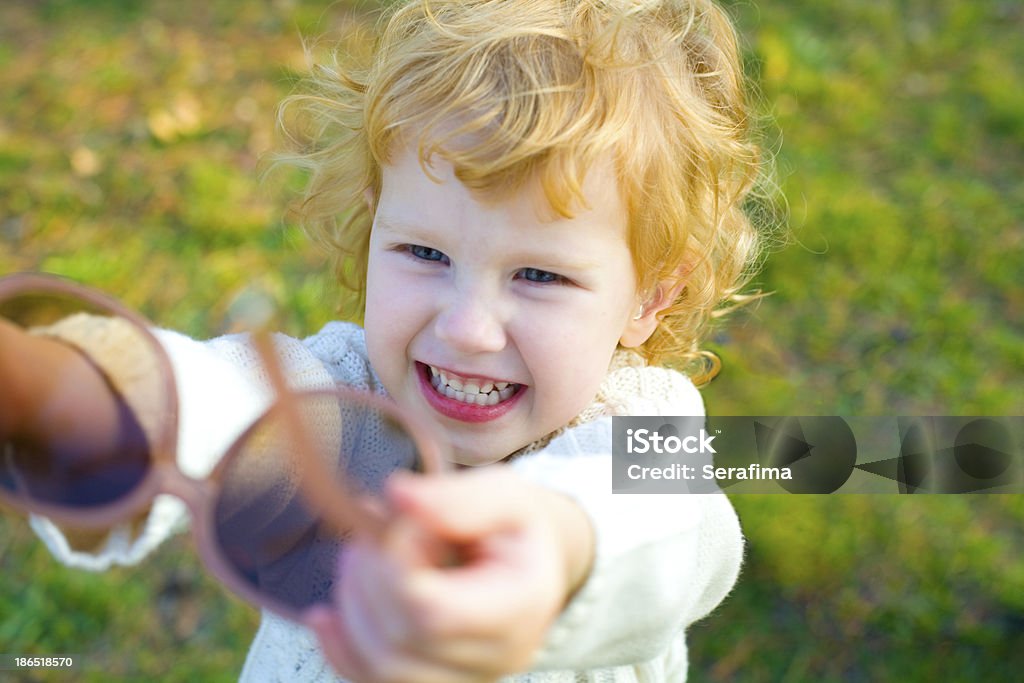 Ridicolo bambina mette in scena i grandi occhiali da sole - Foto stock royalty-free di 2-3 anni