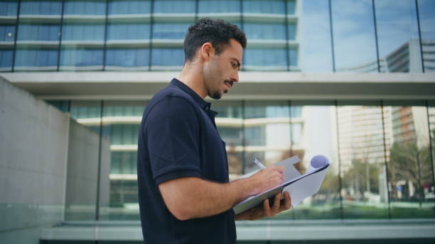 istock Confident businessman studying documents at street close up. Man holding papers 1865195788
