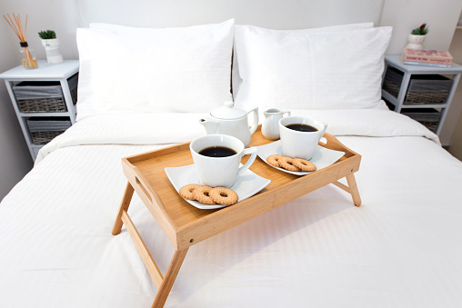 2 cups of coffee and cookies served on a tray in a hotel bedroom