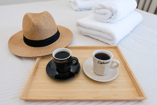 2 cups of coffee,  served on a tray in a hotel bedroom