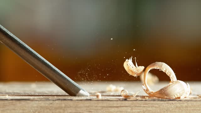 Super slow motion of detail of carving wood with a chisel.