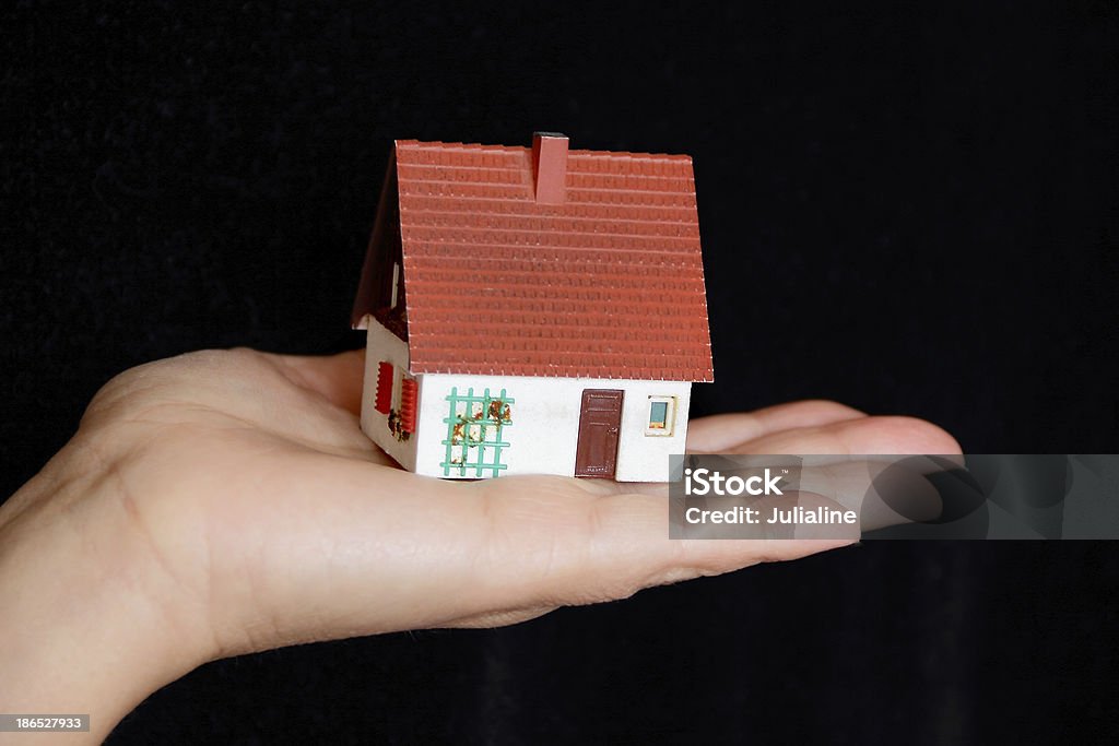 Кукольный домик в человеческой рукой - Стоковые фото Архитектура роялти-фри