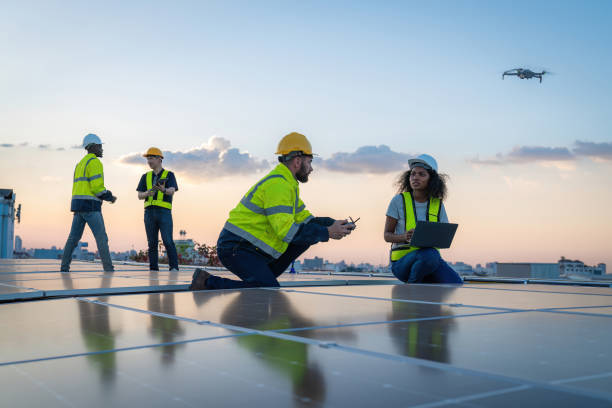 istock Engineer working setup Solar panel at the roof top. Engineer or worker work on solar panels or solar cells on the roof of business building 1865281729