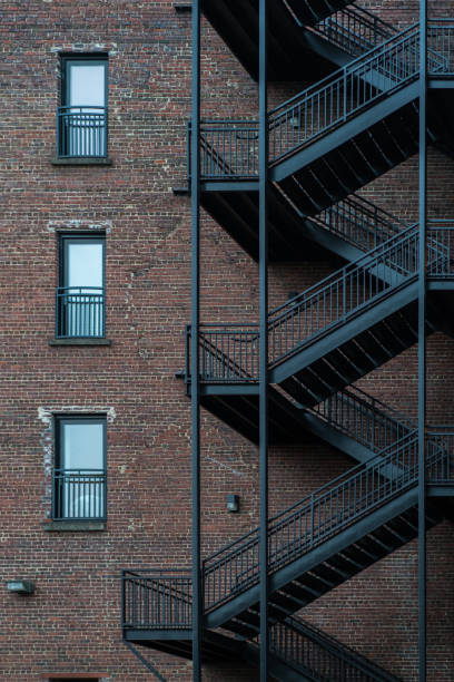 istock Black fire escape stairs on a brick building. 1865294243