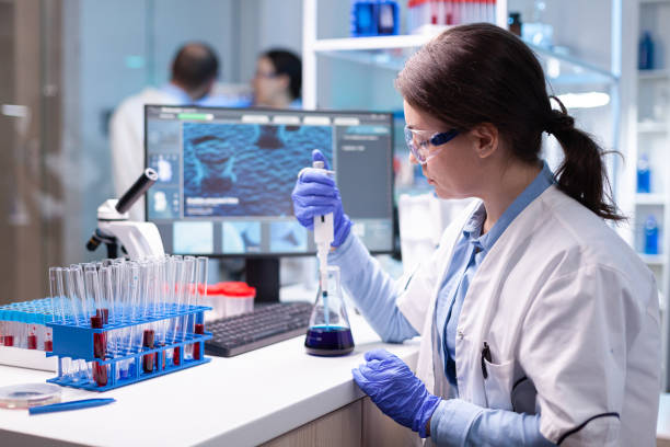 istock Scientist looking at sample into micropipette for biology hospital test 1865306789