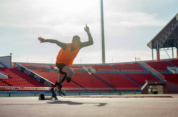 istock Sport man athlete prosthesis legs start run with look forward at the stadium with soft light of evening. 1865352526