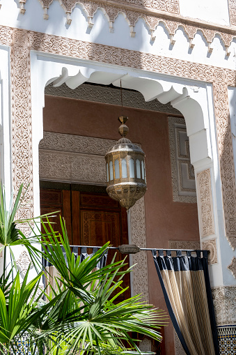 Fez, Morocco - may 16, 2023: view of the balcony and lantern of a traditional riad, a stately home now used as a hotel, in the ancient souk of the medina in Fez, Morocco.