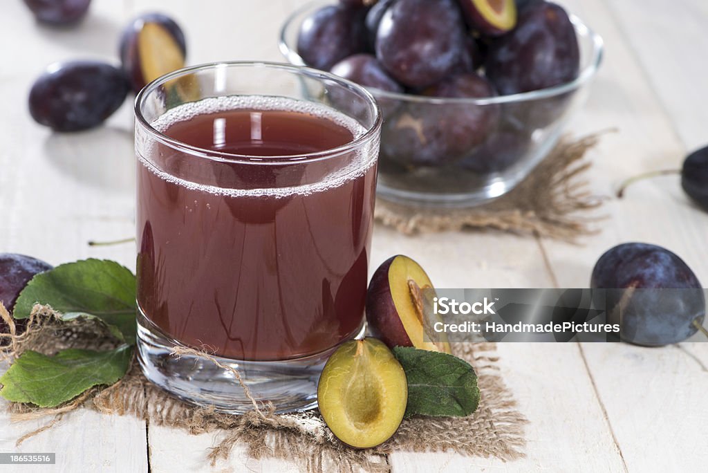 Healthy Plum Juice Portion of healthy Plum Juice on wood Close-up Stock Photo