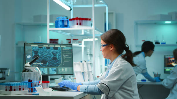 istock Scientist nurse typing on pc late at night working in laboratory 1865372480