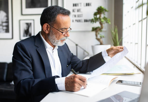 istock serious concentrated caucasian senior businessman in suit with contract types on computer in modern office interior 1865408967