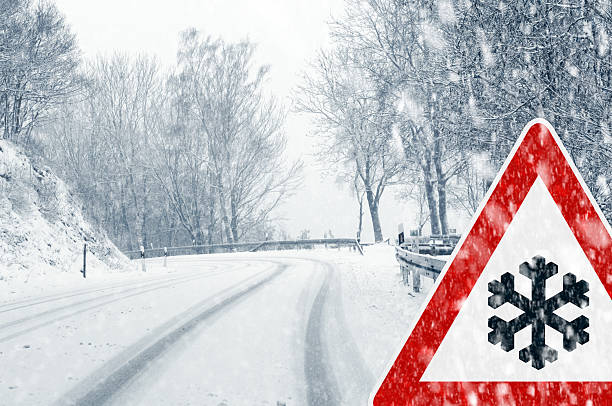 istock Deserted snowy road and trees with snow warning traffic sign 186543376
