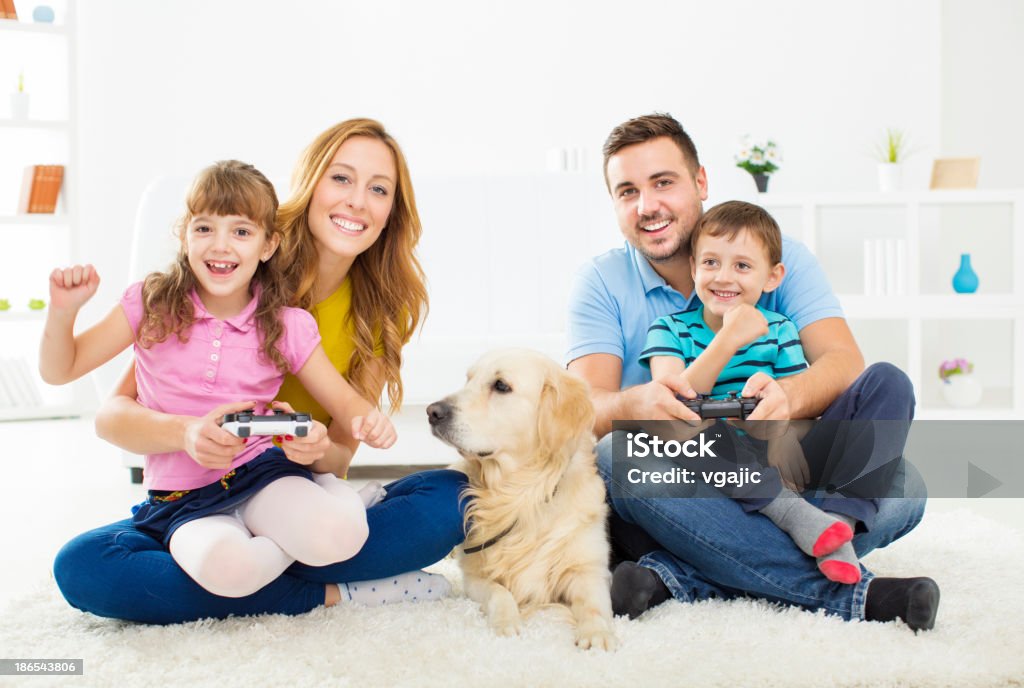 Alegre Família jogando vídeo game em casa. - Foto de stock de Brincalhão royalty-free