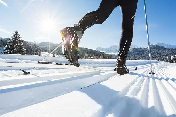 Close-up of a mans legs doing cross-country skiing.