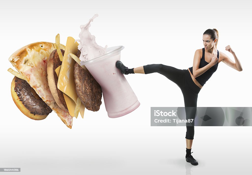 Fit young woman fighting off fast food Food Stock Photo