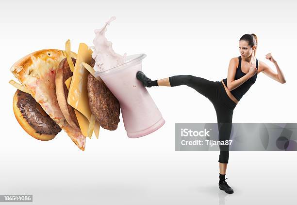 Fit Young Woman Fighting Off Fast Food Stock Photo - Download Image Now - Food, Kicking, Fast Food