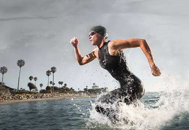 Photo of Female Triathlon Athlete rushing out of the water