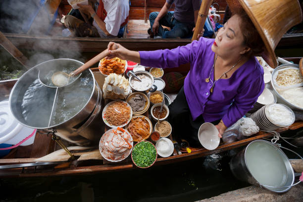 Food vendor at Damnoen Saduak Floating Market, Thailand. Food vendor at the Damnoen Saduak Floating Market preparing Thai style noodles, Thailand. ratchaburi province stock pictures, royalty-free photos & images
