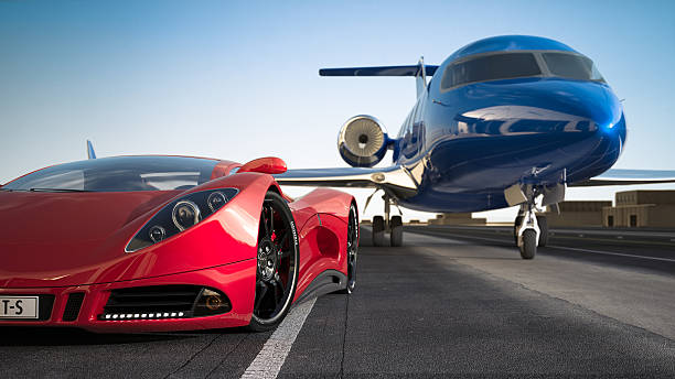 Red sports car and blue luxury jet on runway stock photo