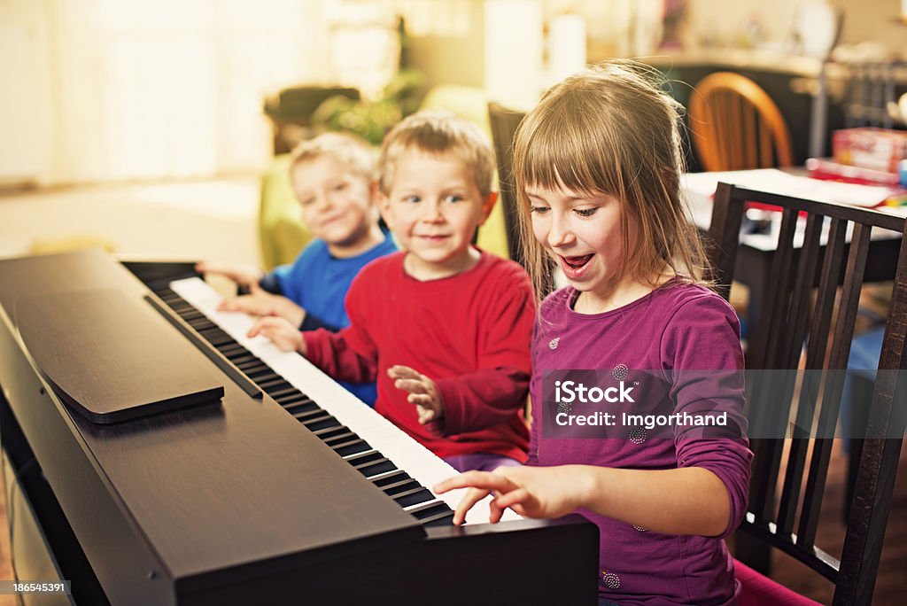 Crianças se divertindo tocando piano - Foto de stock de Criança royalty-free