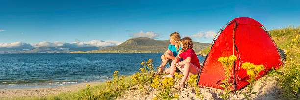 Children camping on idyllic golden beach dunes summer ocean panorama