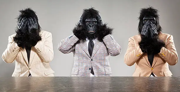 Three gorillas in retro suits showing the Three Wise Monkey poses.