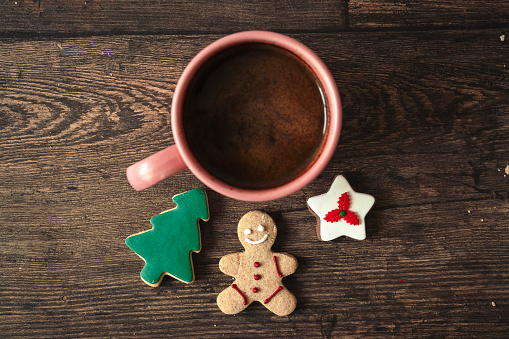 Cup of coffee with christmas cookies on the wooden table