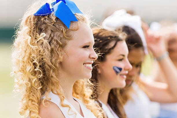 istock Competitive cheerleading squad cheering at football game 186546361