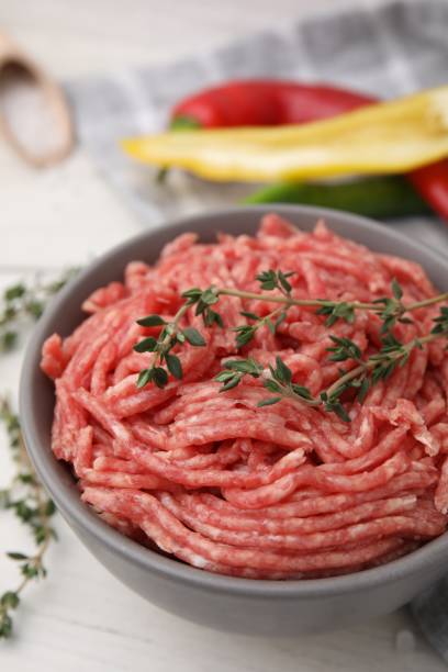 istock Fresh raw ground meat and thyme in bowl on white table, closeup 1865477766