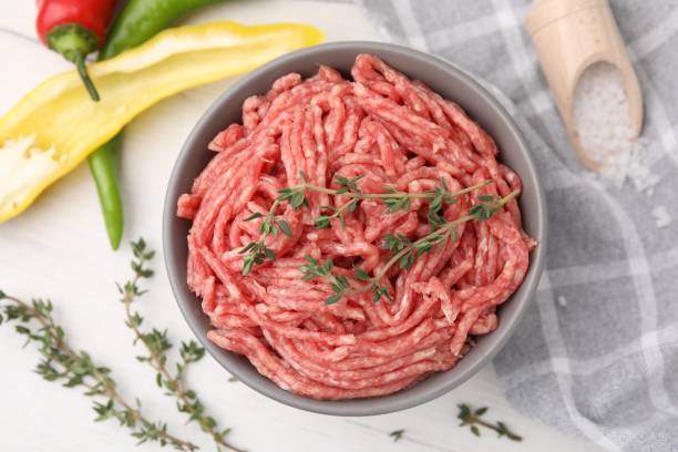 istock Flat lay composition with fresh raw ground meat and thyme in bowl on white table 1865479404