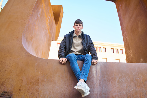 portrait of a caucasian man sitting in the city looking at the camera