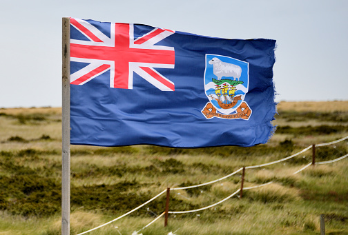 National flags of UK, USA and France against blue sky