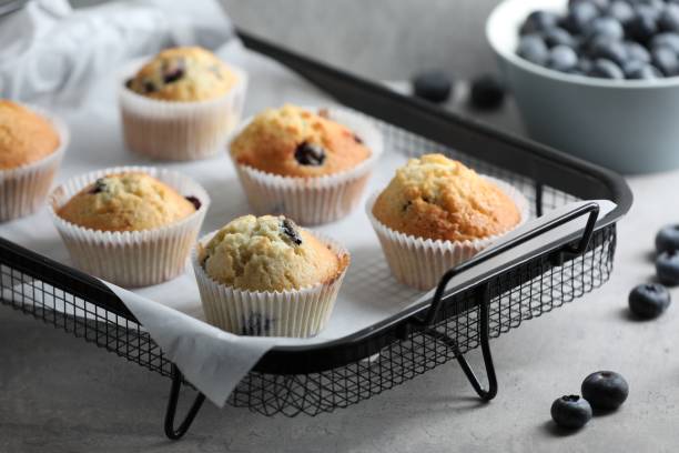istock Delicious sweet muffins with blueberries on grey table 1865493319