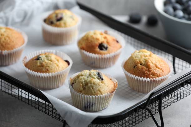 istock Delicious sweet muffins with blueberries on grey table 1865493324